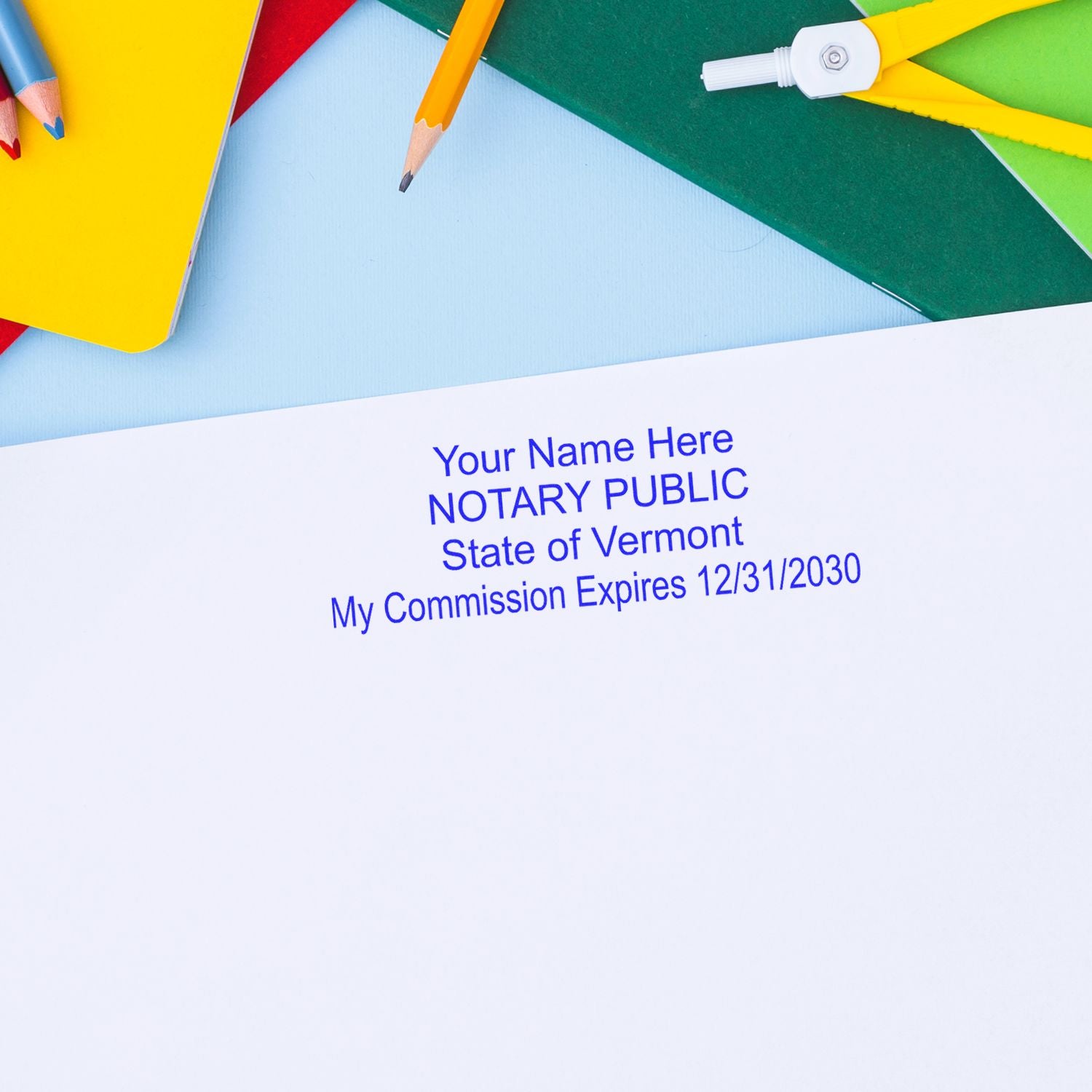 Vermont notary public commission stamp with colorful pencils and office supplies on paper document