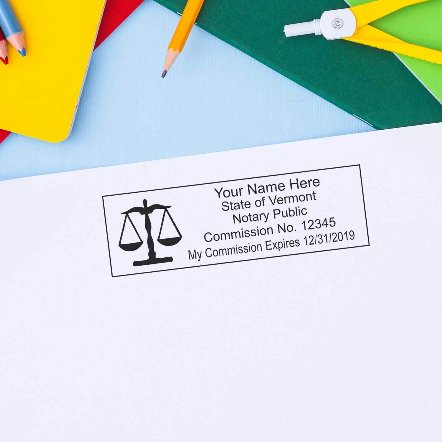 Vermont notary public stamp on document with colorful pencils and stationery background