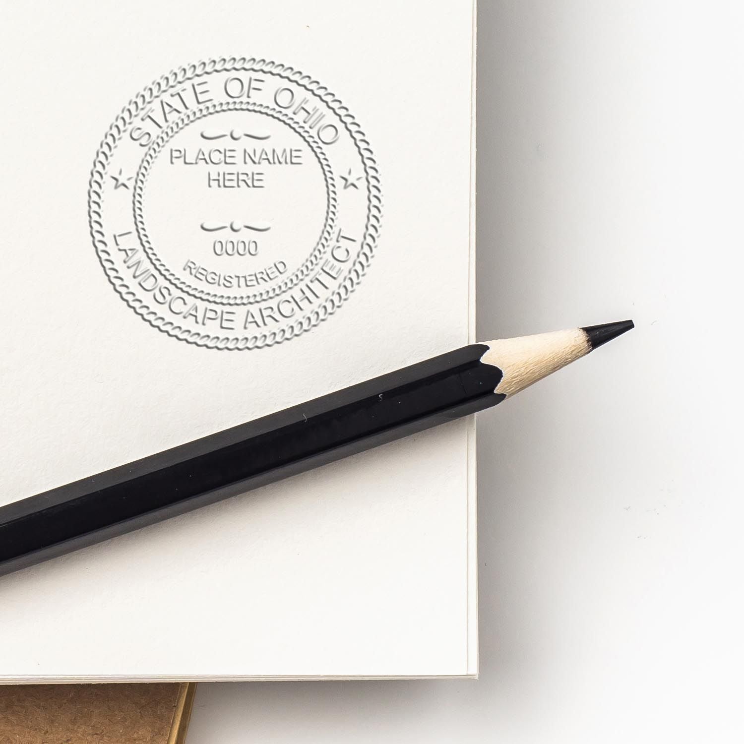 Embossed Ohio State landscape architect seal on a white sketchbook page with a black pencil.