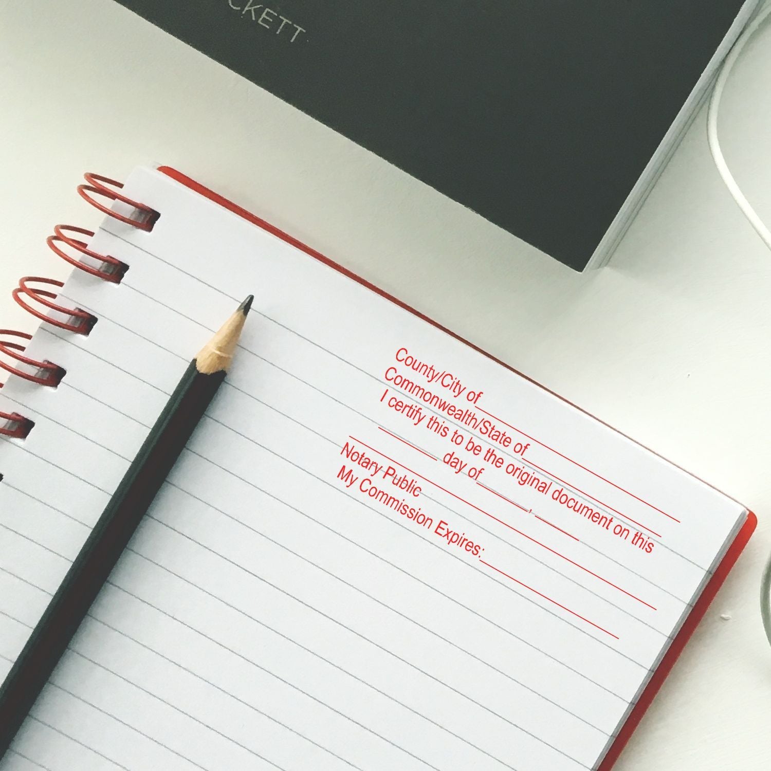 Notary public journal notebook with pencil for document certification and official record keeping.