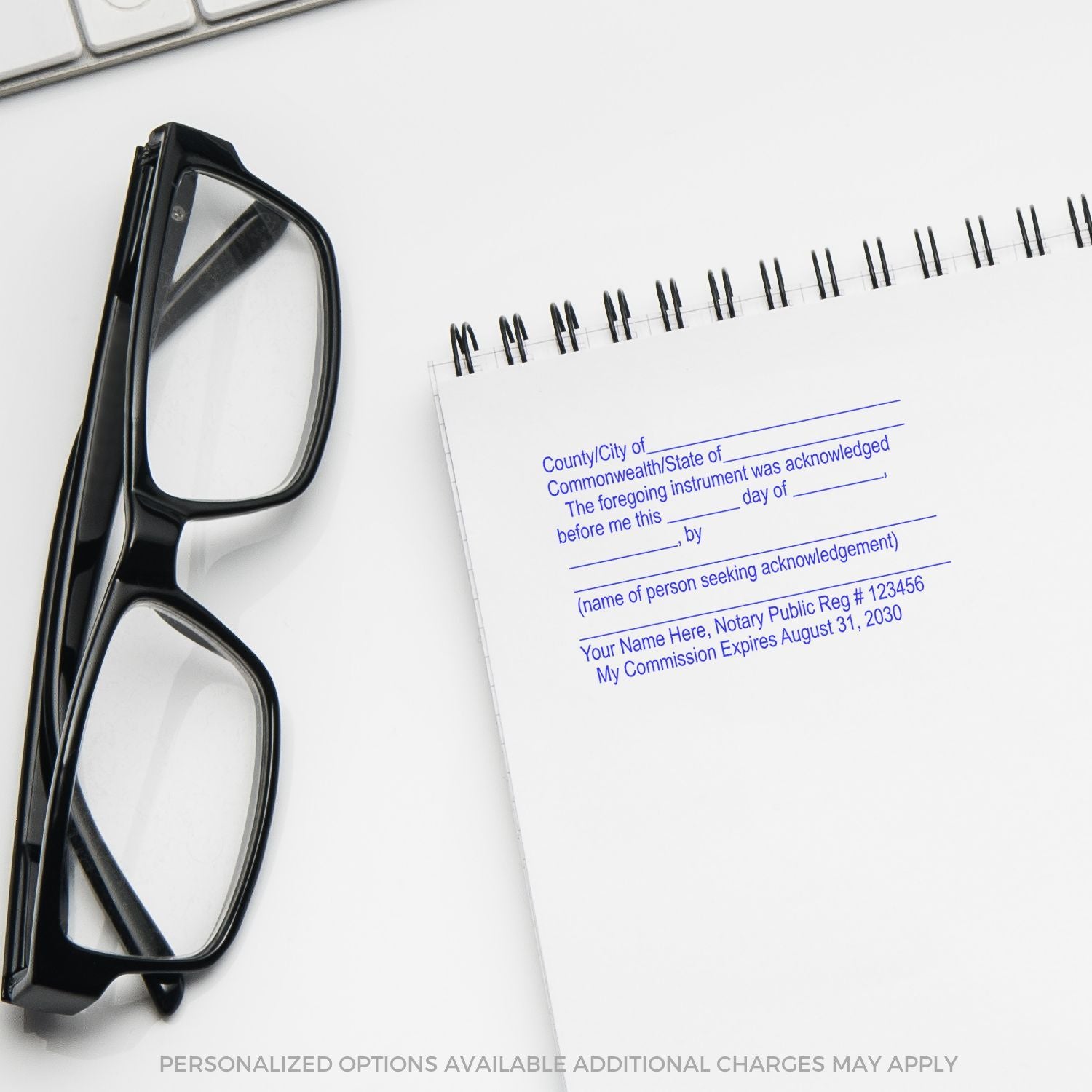 Black eyeglasses beside a notary public acknowledgment pad on a white office desk, with keyboard in the background.