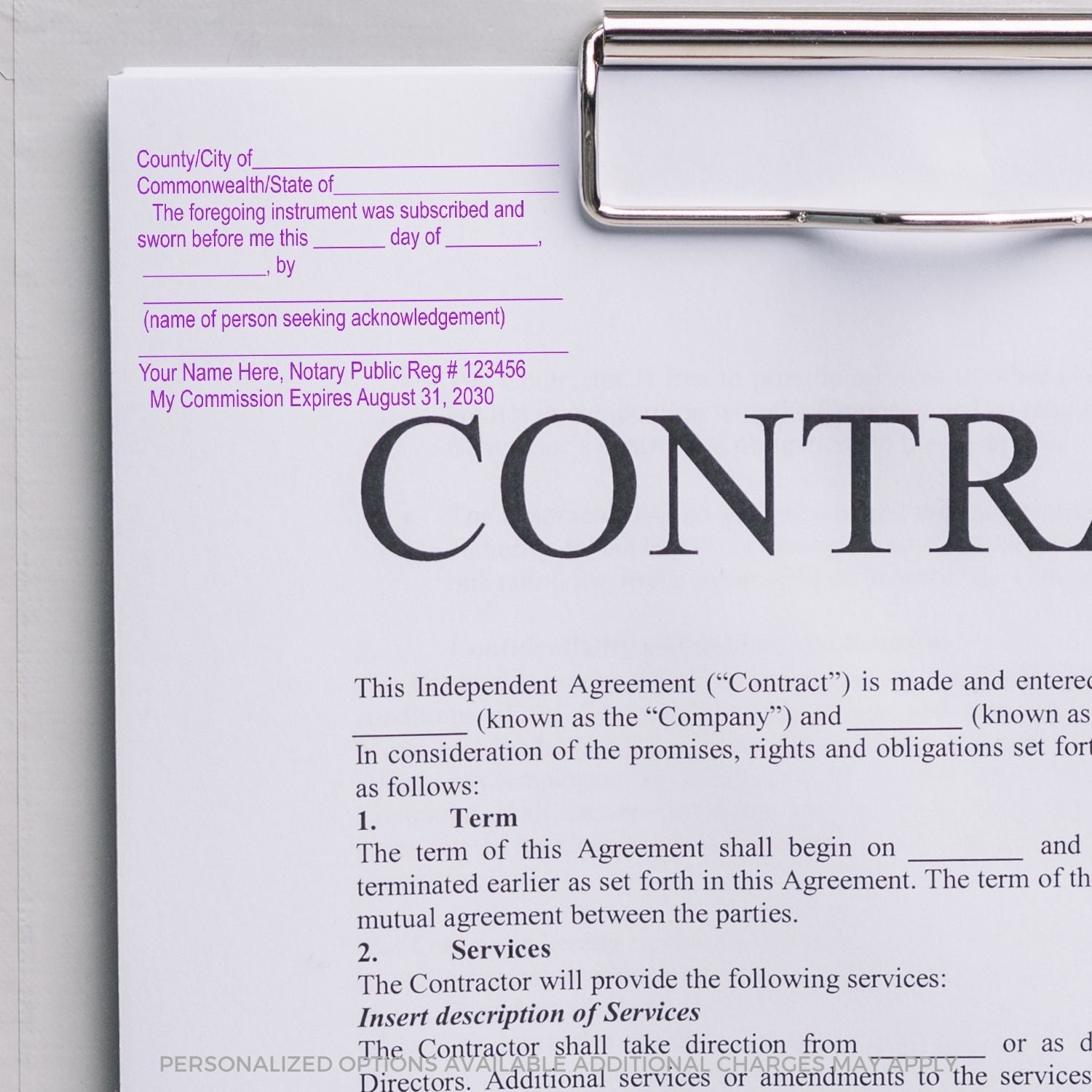 Close-up of a notarized independent contractor agreement on a clipboard with blank notary acknowledgment fields and contract terms visible.