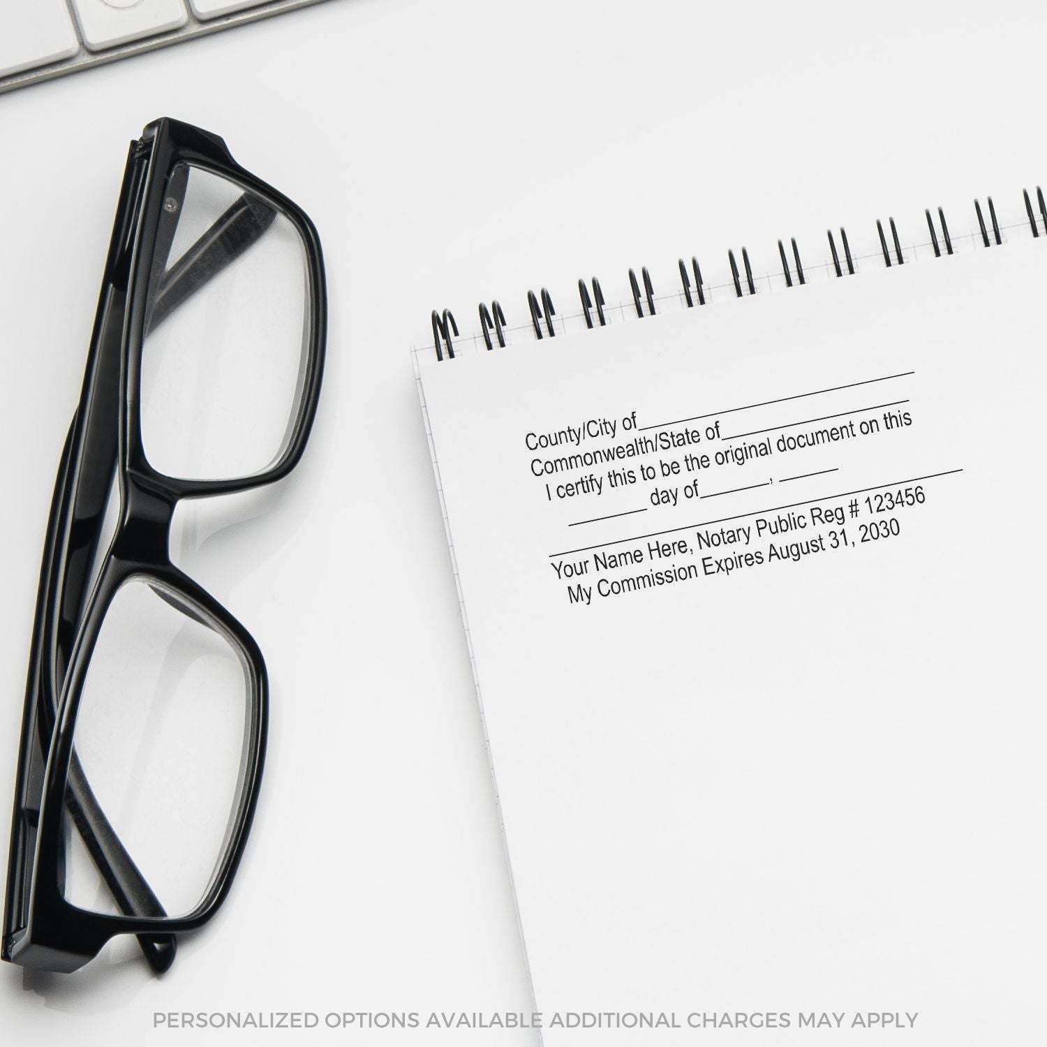 Black eyeglasses beside a notary public certificate notebook on a white desk