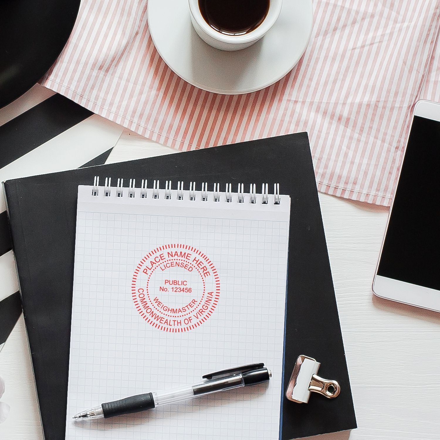 Virginia notary public seal on notepad with pen, coffee cup, clipboard and smartphone on desk