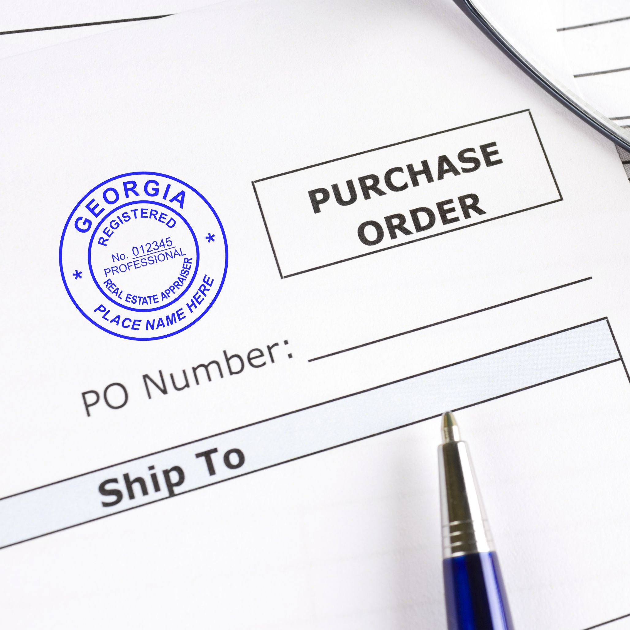Purchase order form with Georgia real estate appraiser stamp and pen, close-up business document.