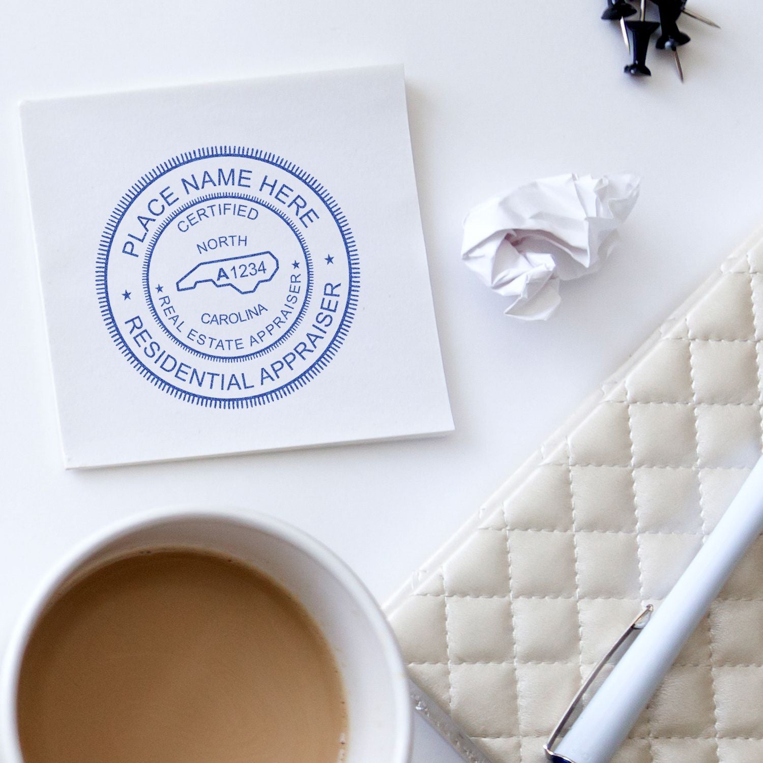 Residential appraiser desk flat lay with coffee, pen, notebook, and real estate appraisal stamp