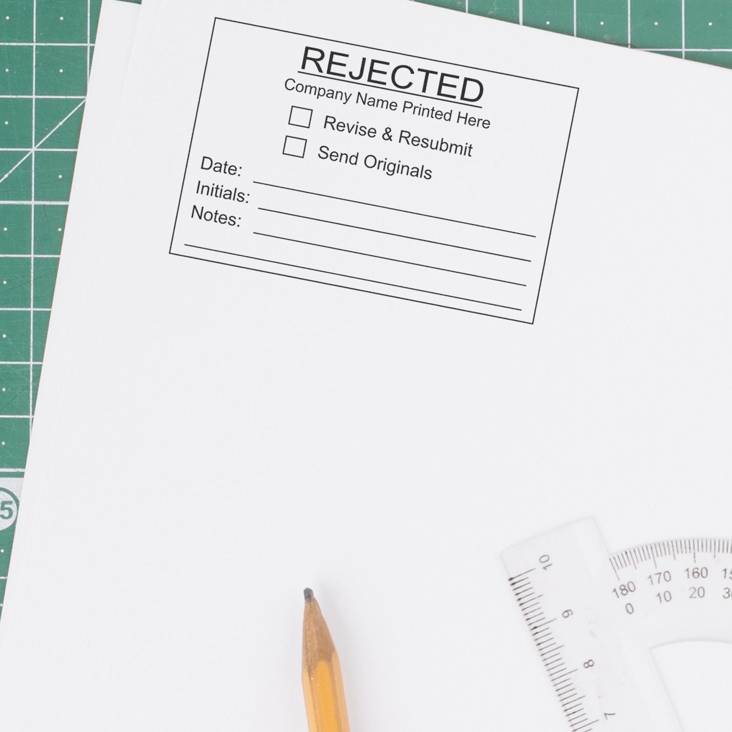 Rejected stamp on blank paper with pencil and ruler on cutting mat, office document approval concept.