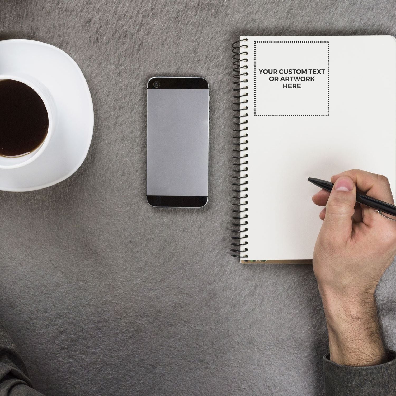 Overhead workspace mockup with smartphone, coffee cup, and notebook page for custom text or artworkbranding, notes, and design.