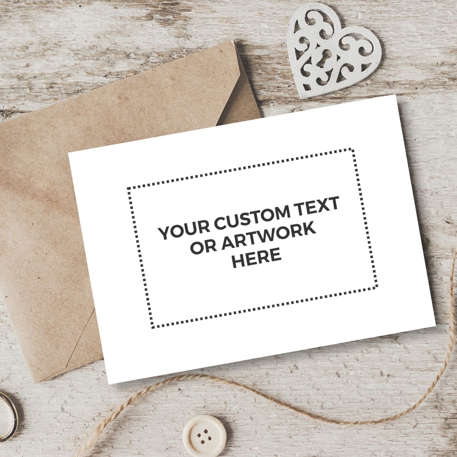 Custom greeting card mockup on rustic wood with kraft paper envelope and heart embellishment, featuring space for your text or artwork.