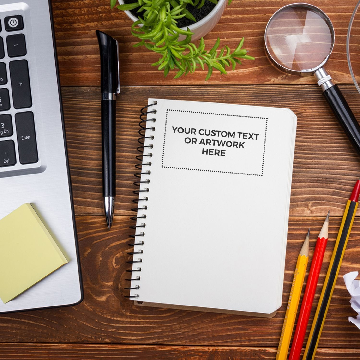 Top view design template with notebook for custom text or artwork, pens, magnifying glass, and desk setup for marketing mockups.