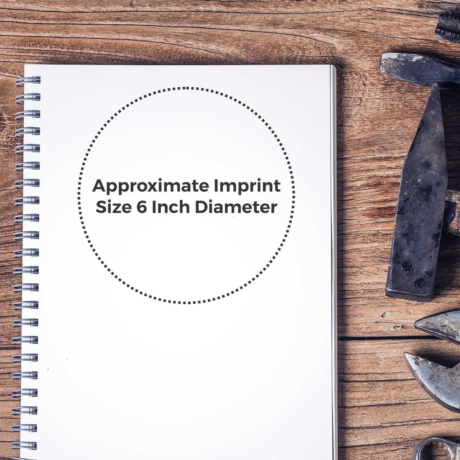 Flat lay of notebook with Approximate Imprint Size 6 Inch Diameter label, indicating logo print area for products on workshop tools wooden background.