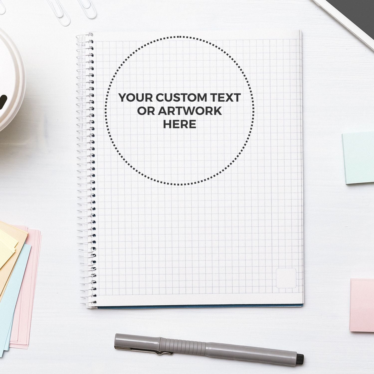 Marketing template with open notebook and dotted circle placeholder for custom text or artwork on a grid paper background