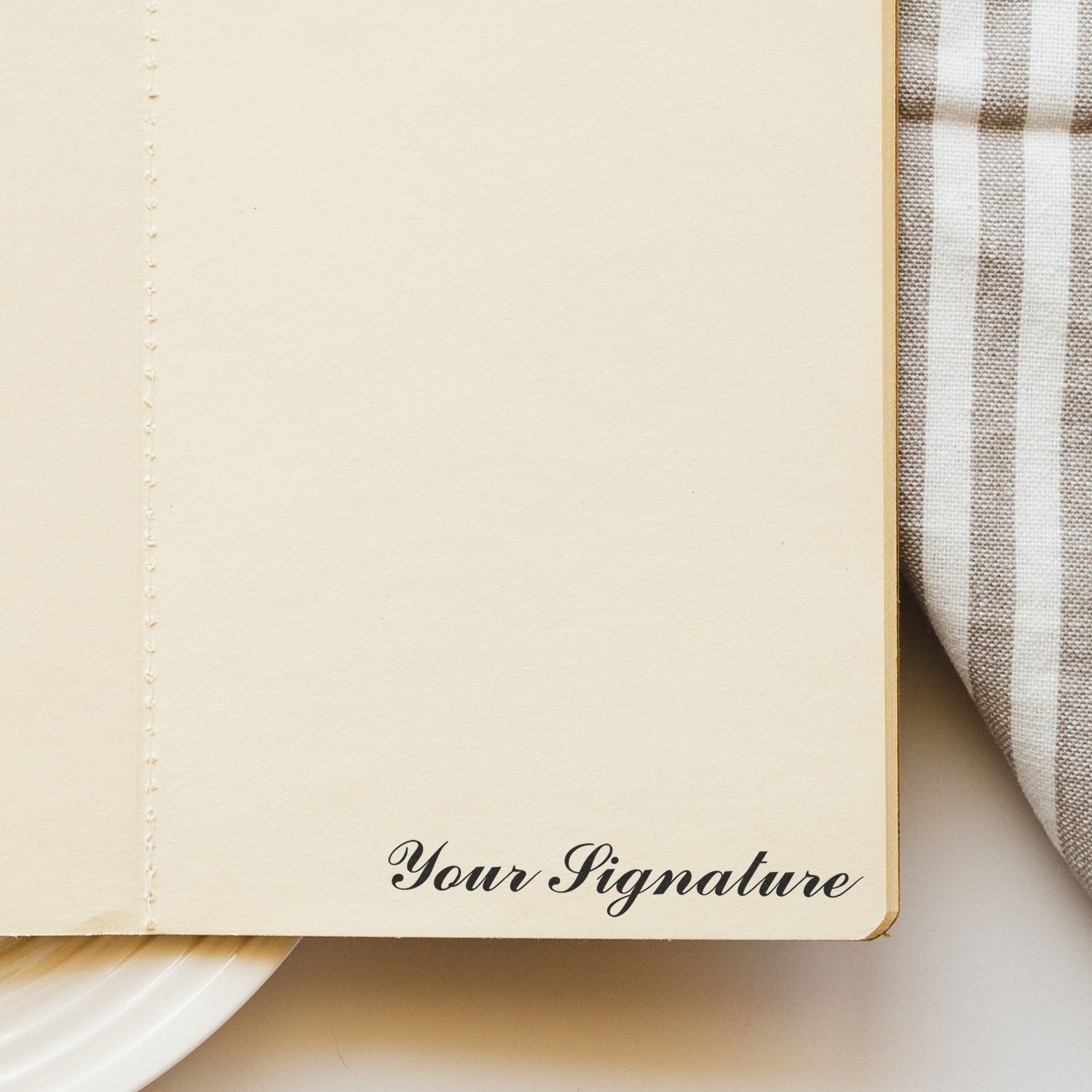 Blank personalized notebook page with Your Signature text, minimalist stationery flat lay on plaid fabric background