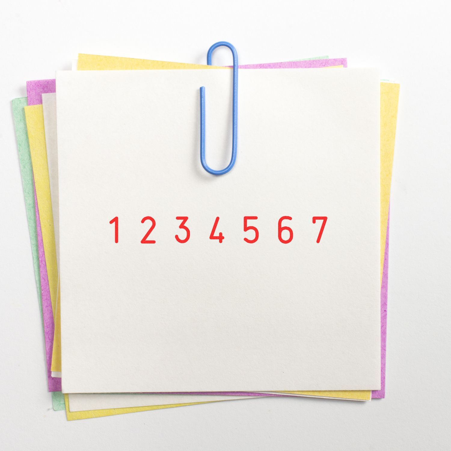 Colorful stack of blank note cards clipped with a blue paperclip, featuring red numbers 1 to 7