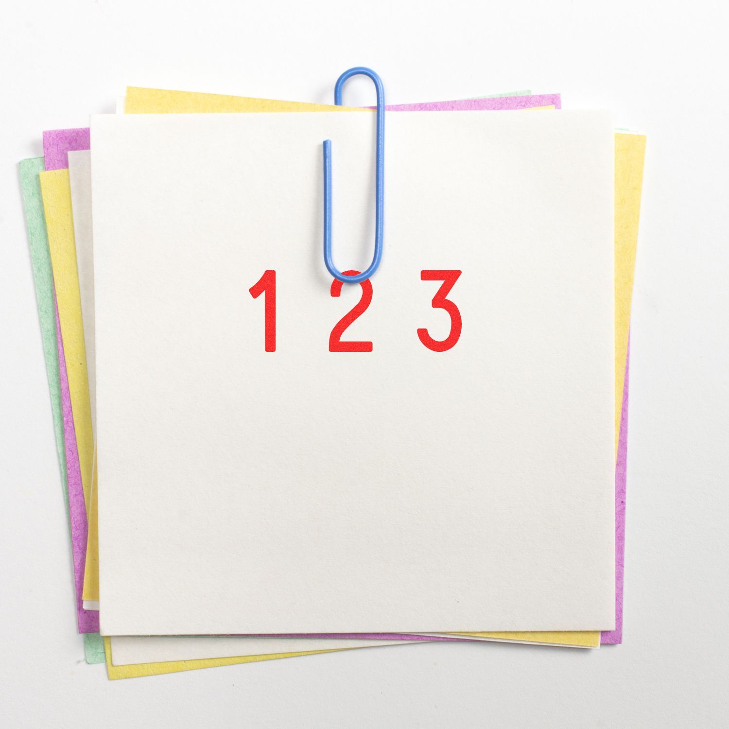 Blank stacked note cards clipped with a blue paperclip and red numbers 1 2 3 on a white background.