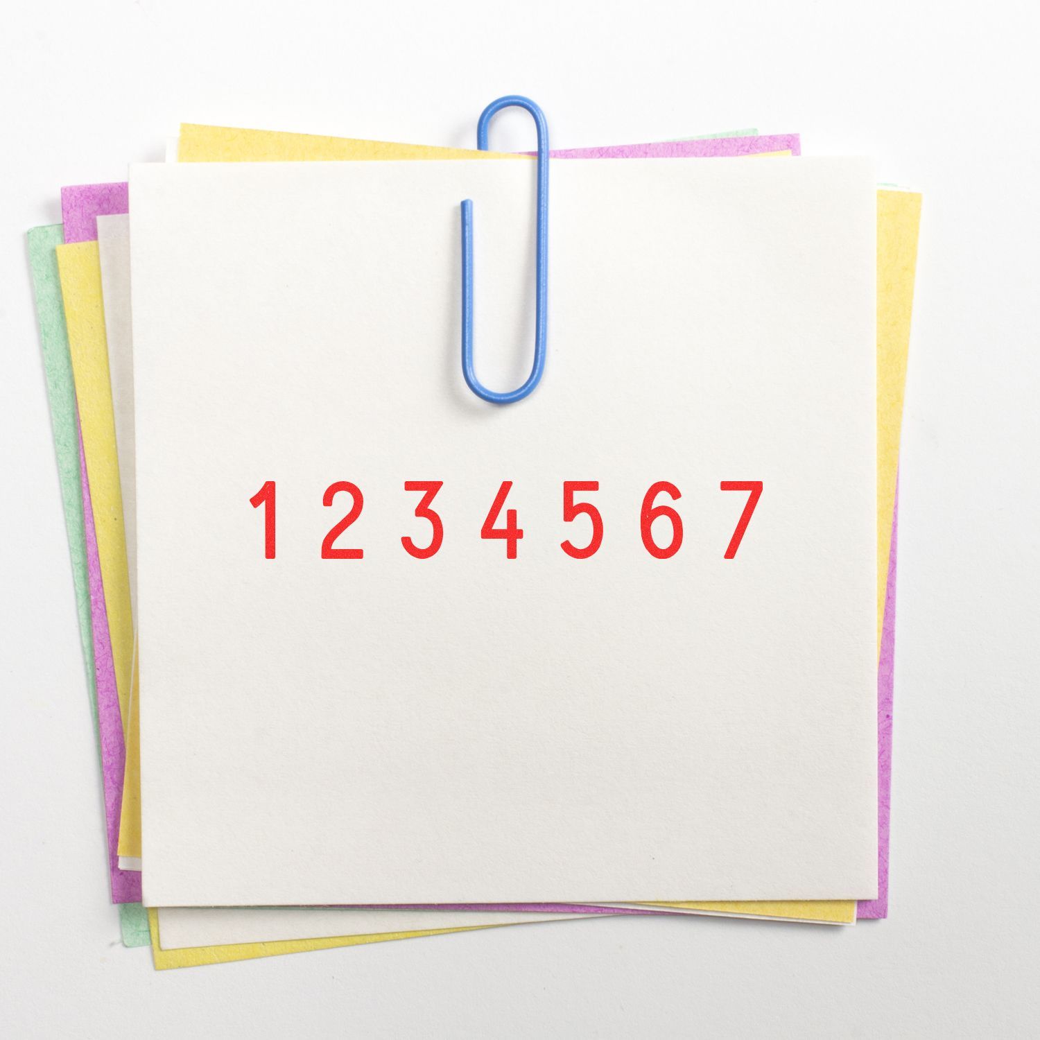 Colorful stack of blank sticky notes clipped with a blue paperclip, marked with red numbers 1 through 7.