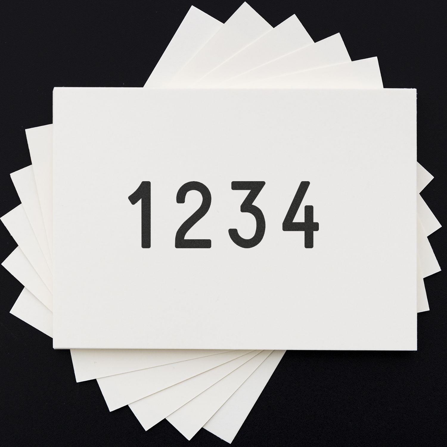 Stack of blank white paper cards with the number 1234 on a black background.