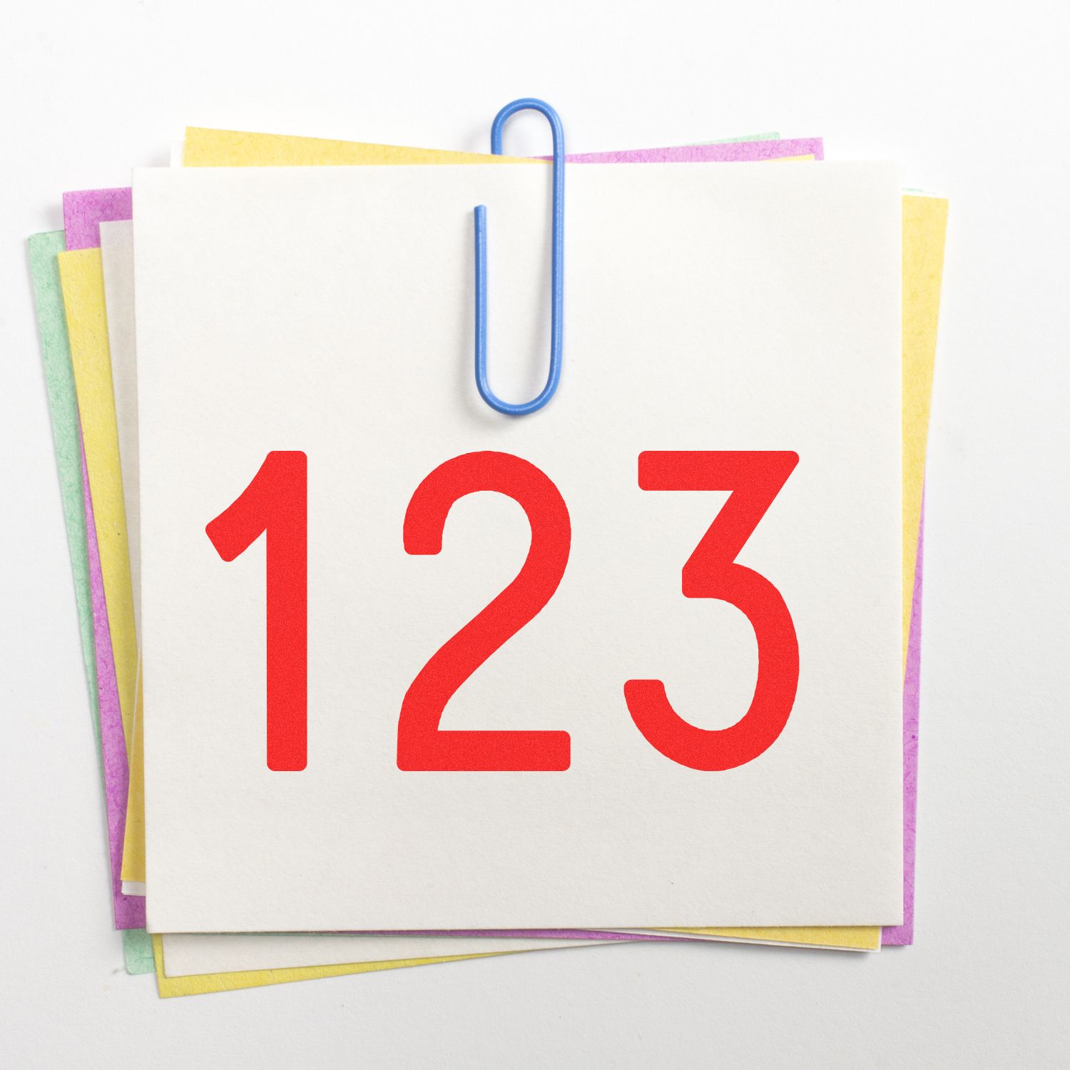 Colorful stack of blank note cards clipped with a blue paperclip and bold red number 123 on white background.