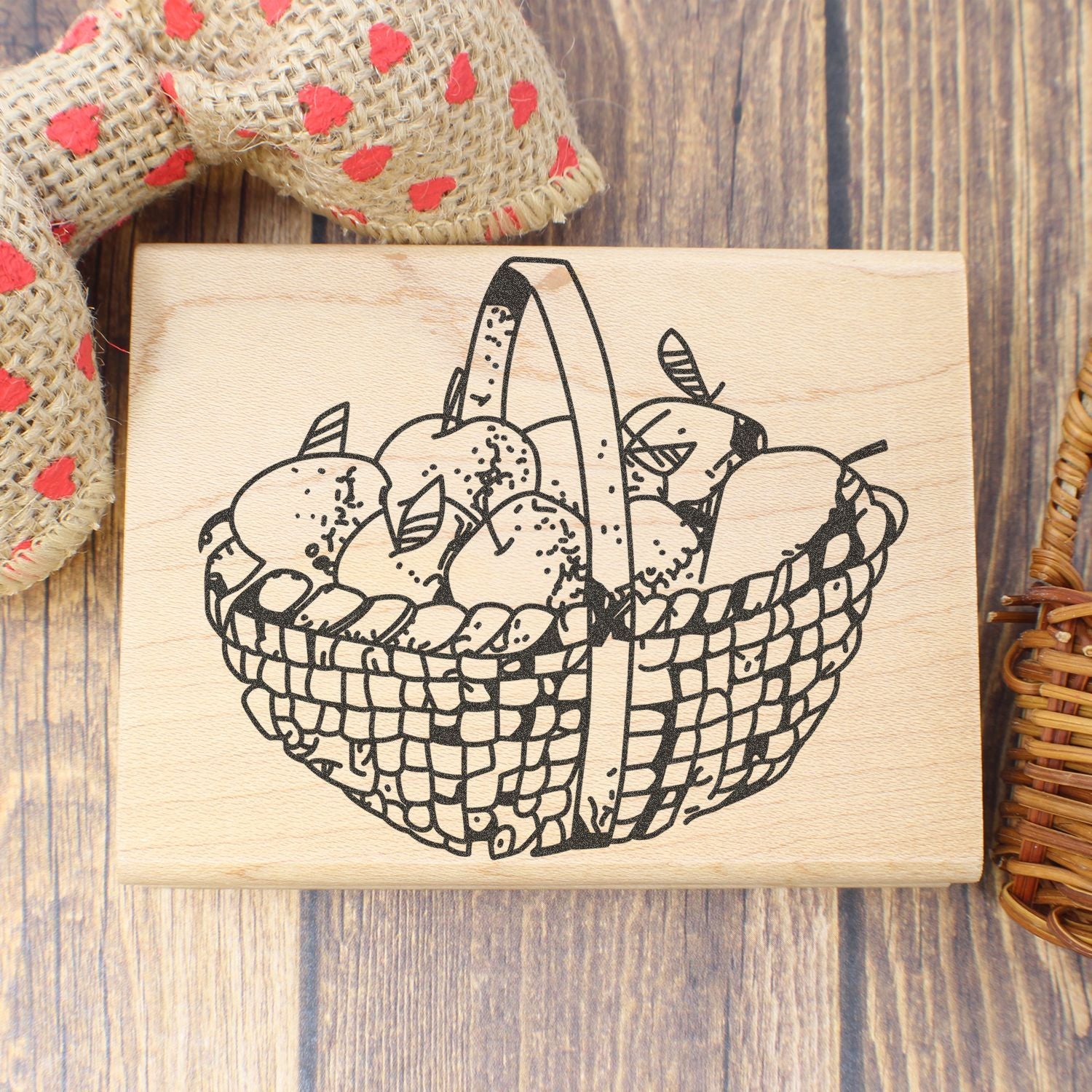 Rustic wooden stamp with hand-drawn basket of apples on a farmhouse wood background
