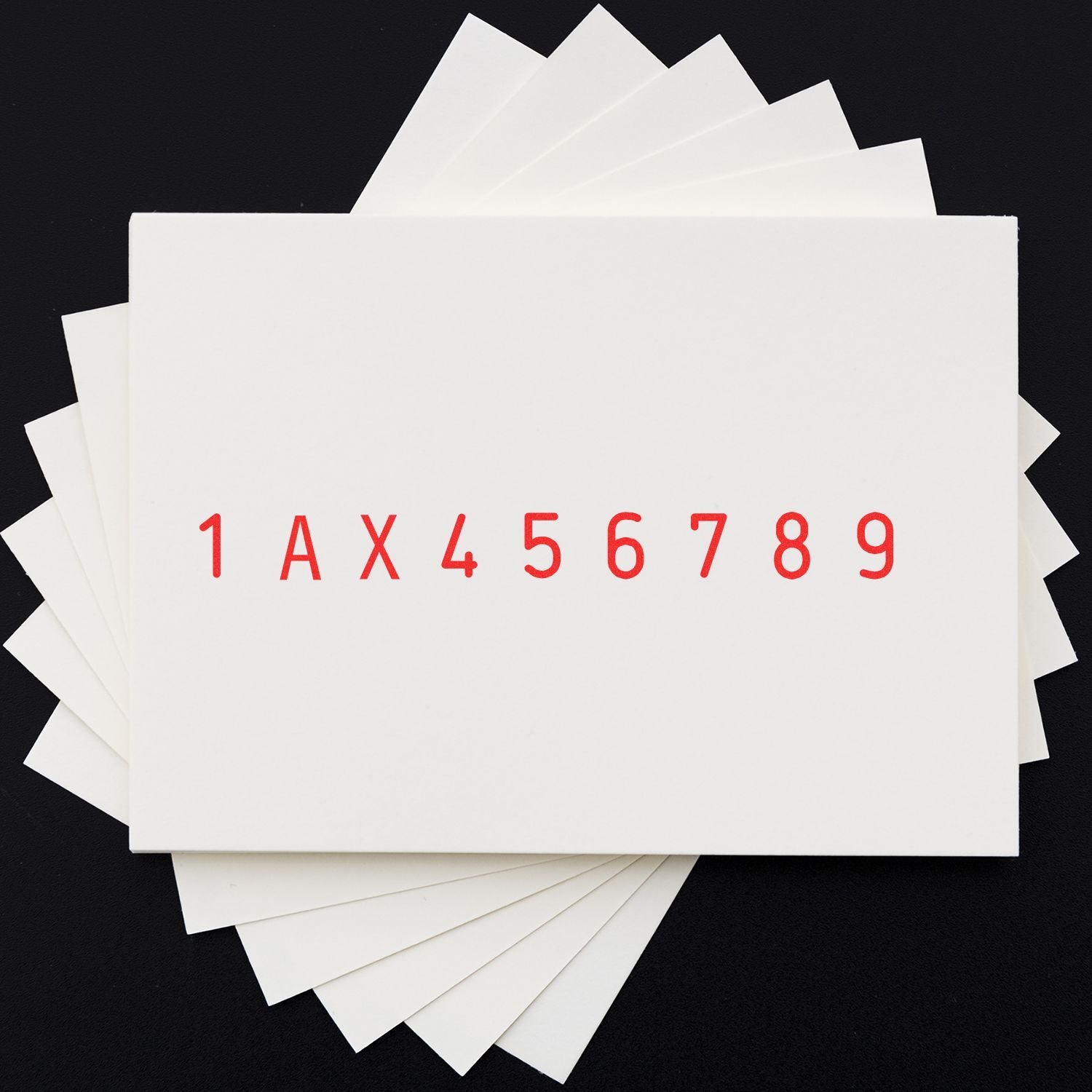 Stack of white index cards with red numbers and letters on a black background, arranged in a fan pattern.