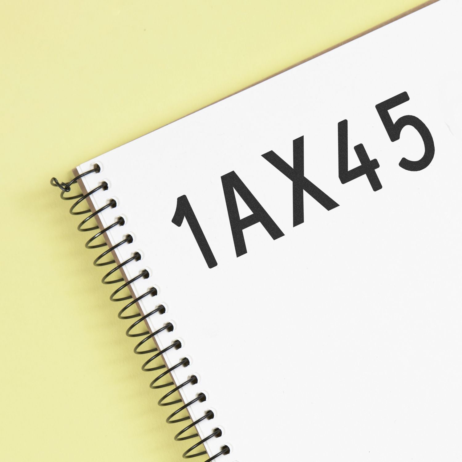Spiral notebook with 1AX45 text on a yellow background, minimalist office and tax concept image
