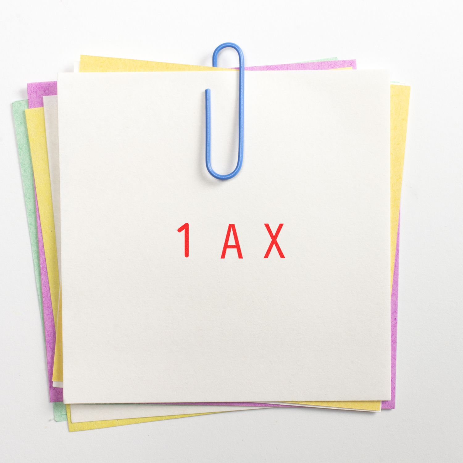 Stack of tax documents clipped together on a white background with colorful paper edges and 1AX text.