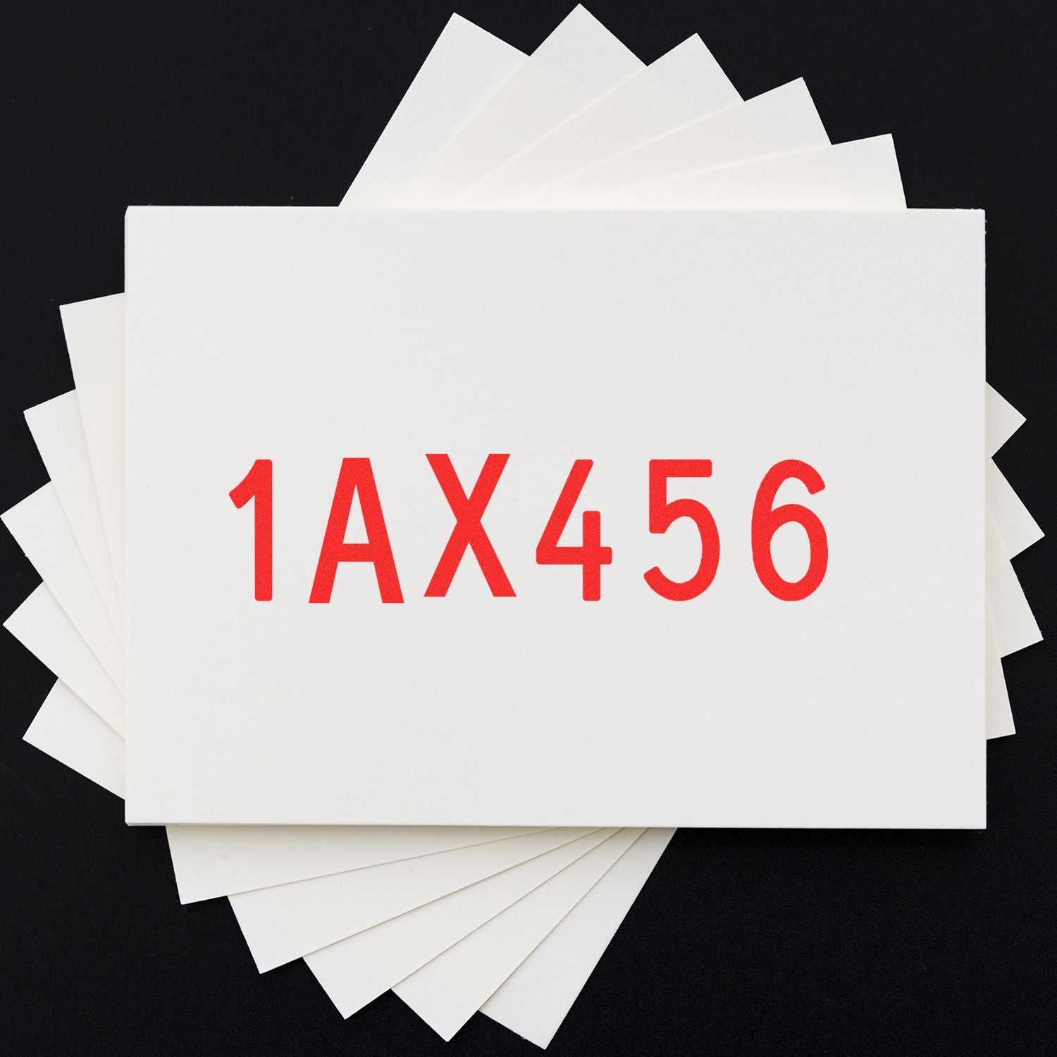 Stack of white paper sheets with red 1AX456 text on a black background.