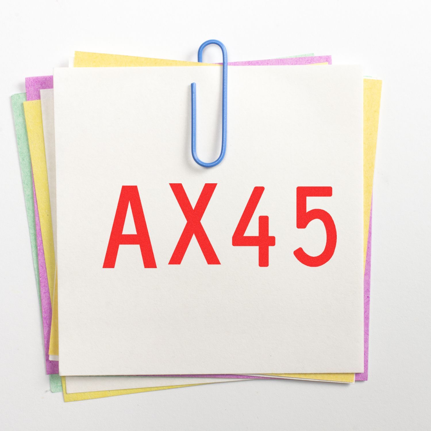Colorful sticky notes clipped together with paperclip and AX45 label on white background