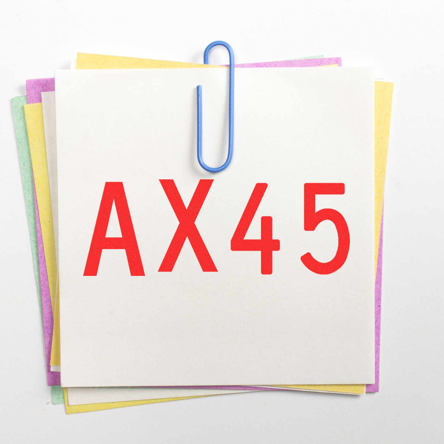AX45 label on stacked colorful paper notes clipped with a blue paperclip on a white background