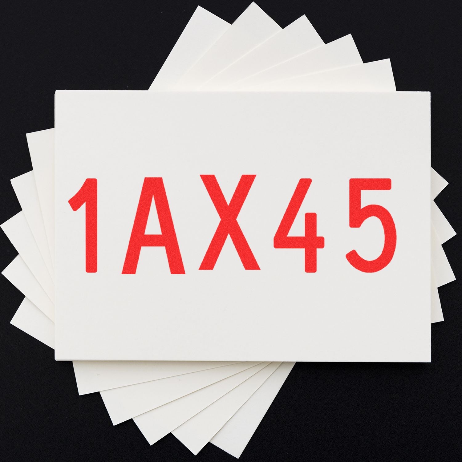White sample cards fanned out with red 1AX45 code on a black background.