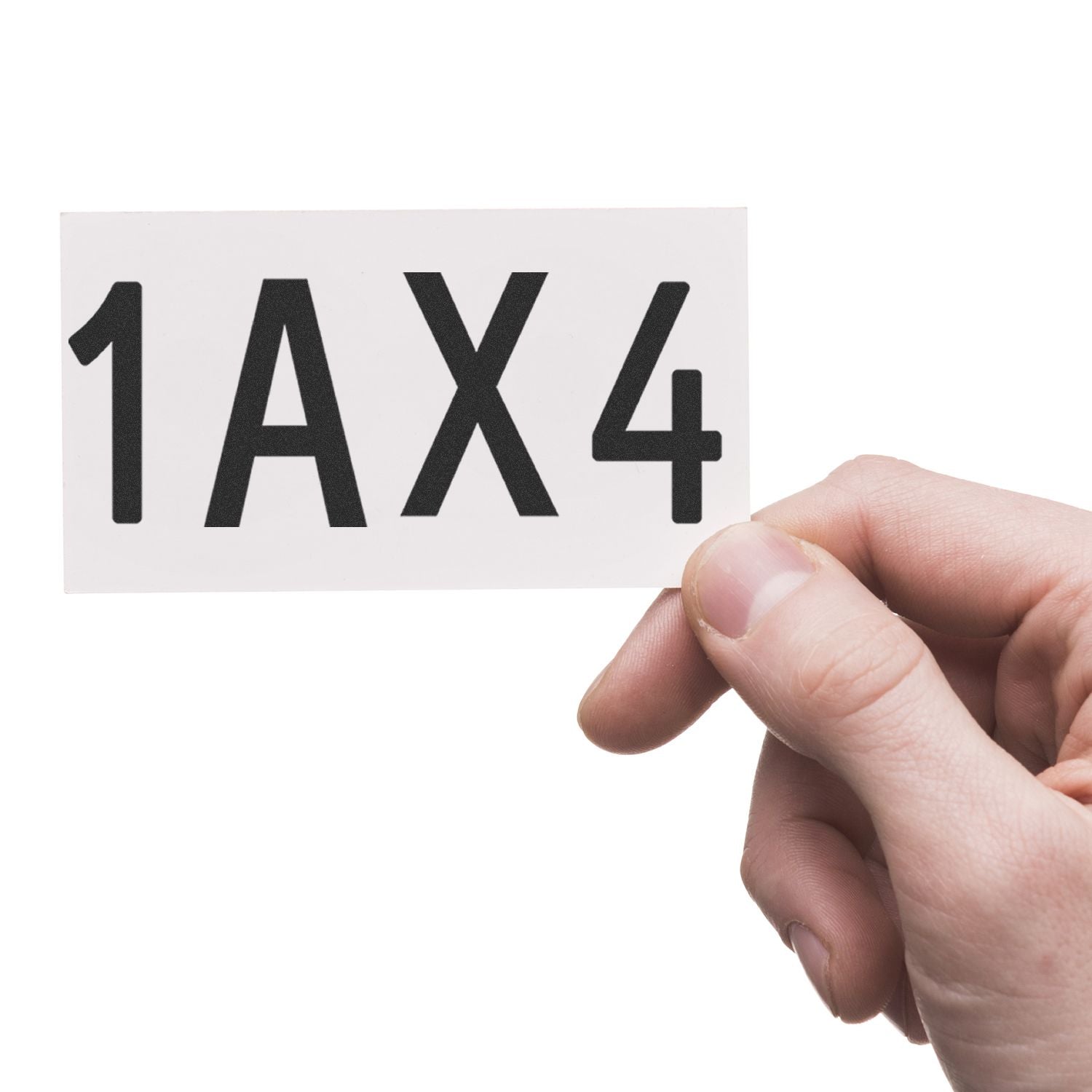 Hand holding a white card with bold black 1AX4 text on a white background.
