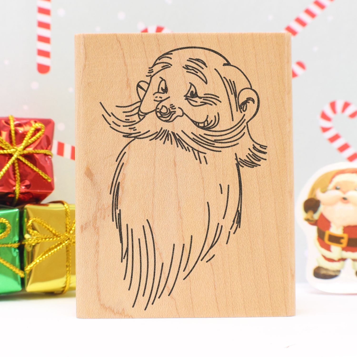 Santa Claus wooden rubber stamp with festive Christmas gifts and candy canes background