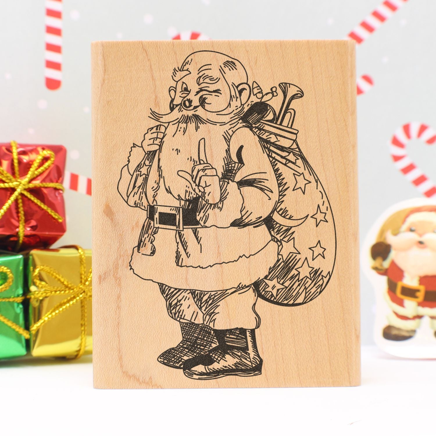 Wooden Christmas stamp with Santa Claus illustration, festive gift wrapping design, and holiday presents background