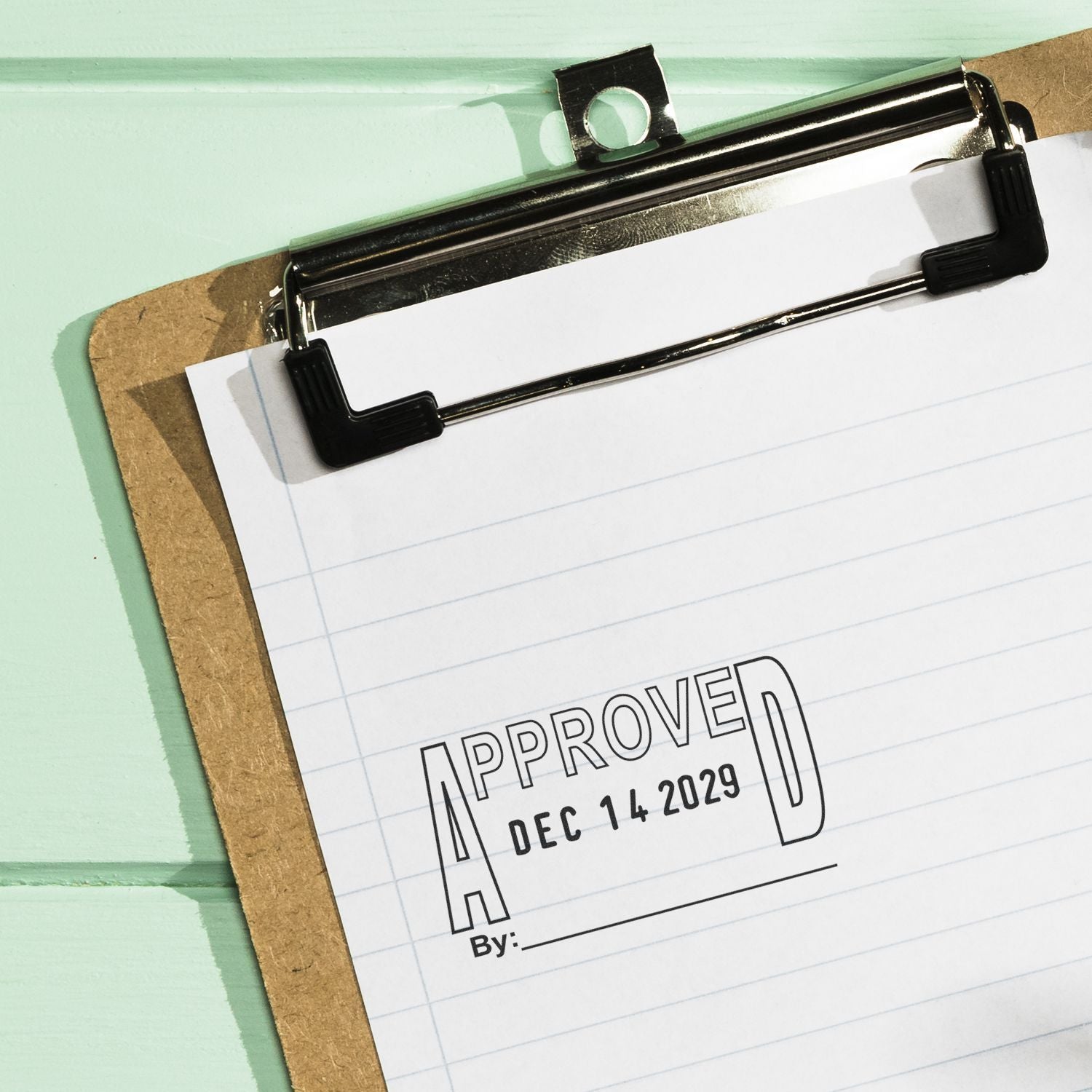 Clipboard with lined paper showing approved stamp and date, business document approval concept.