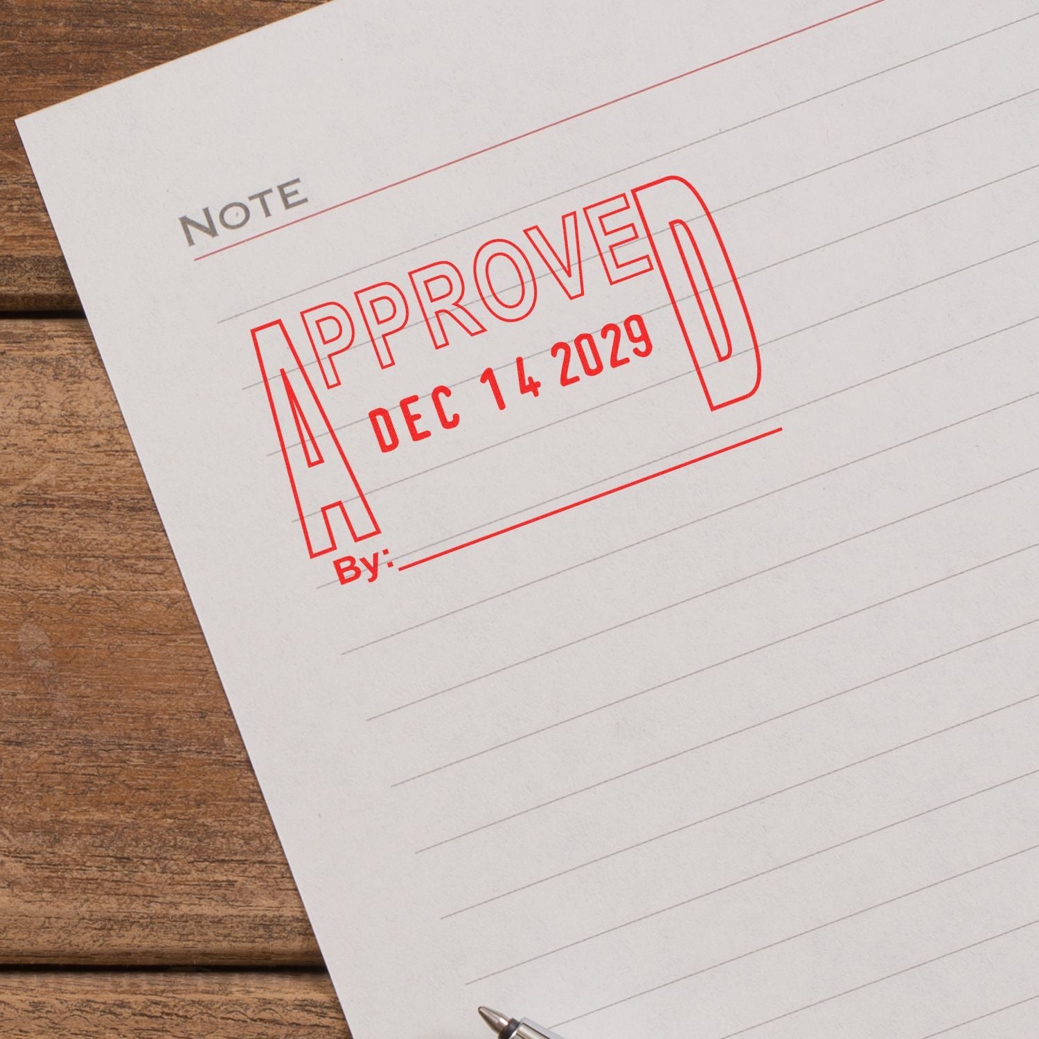 Approved stamp on lined note paper on a wooden desk, business document approval concept.