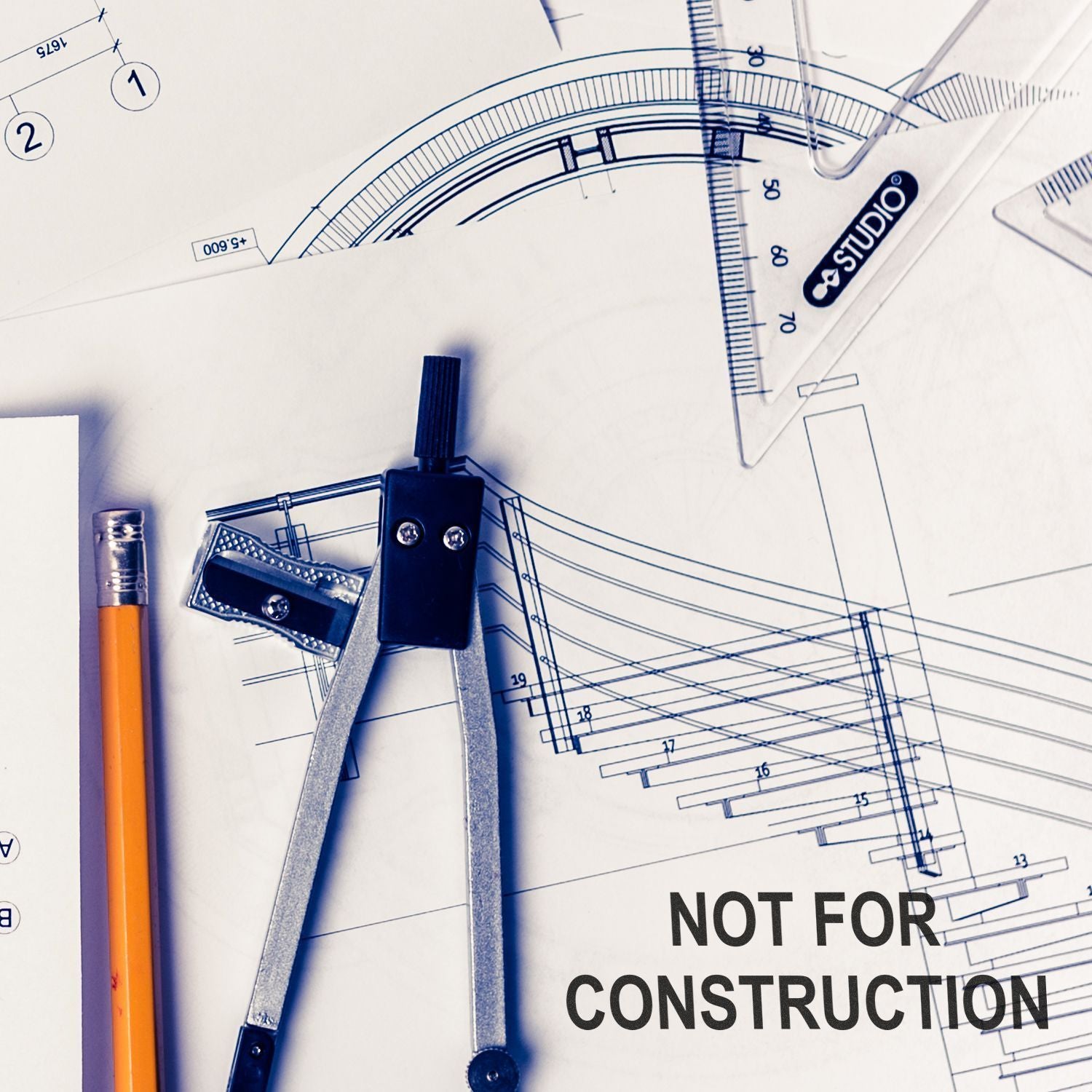 Architectural blueprint with drafting tools, pencil, compass, and ruler on a detailed plan marked not for construction.