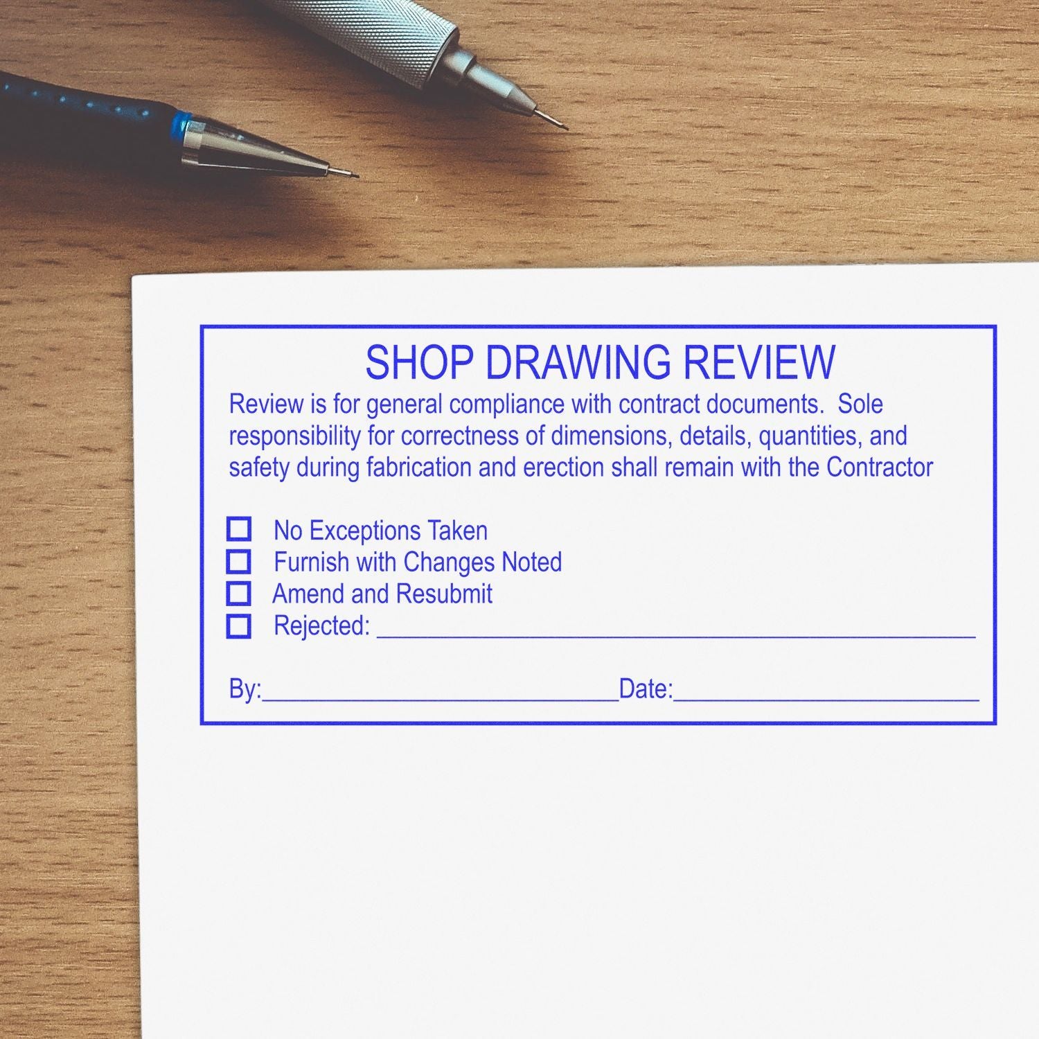 Shop drawing review form on desk with pens, construction document approval checklist and approval options.