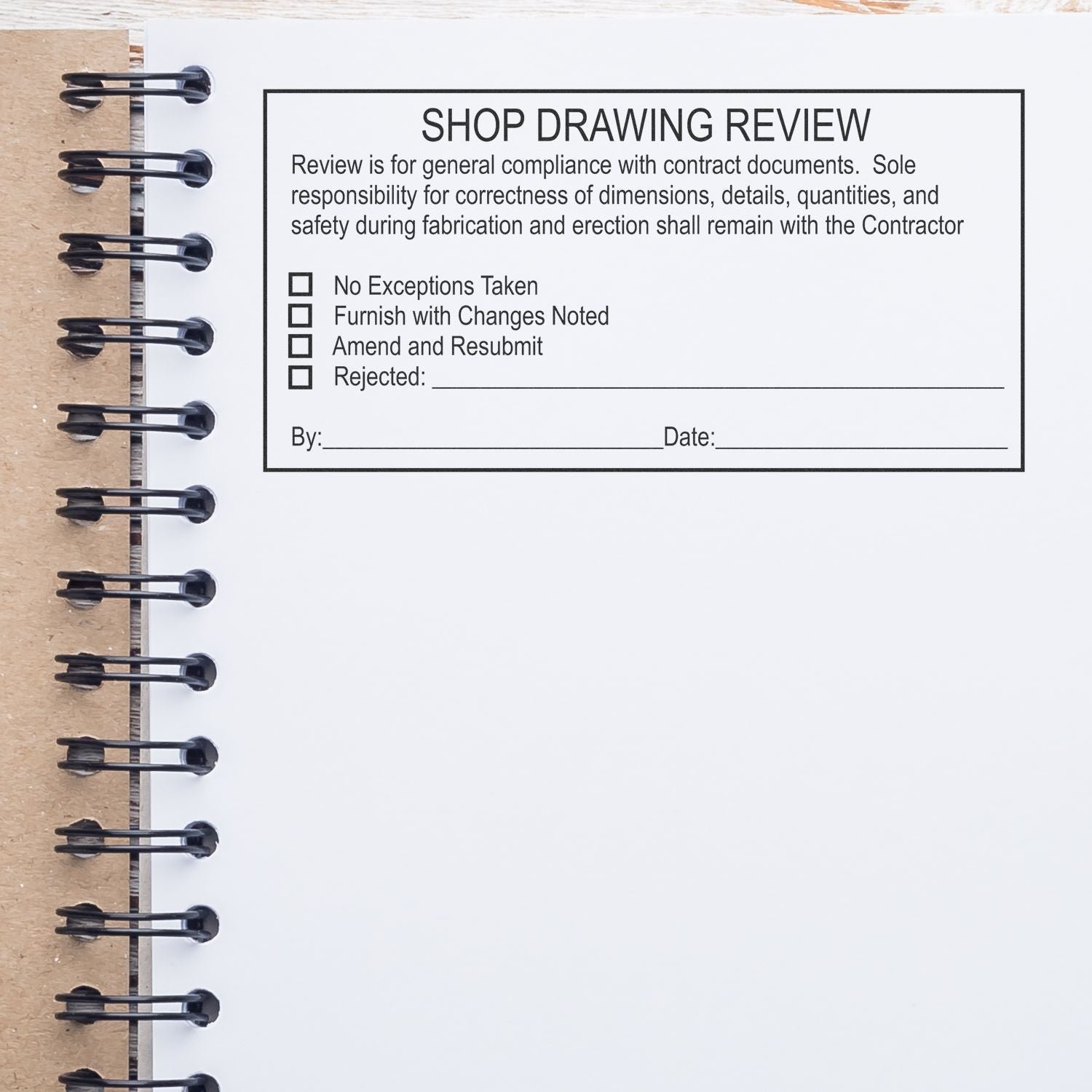 Blank shop drawing review form on a spiral notebook page, with construction approval checkboxes and signature lines.