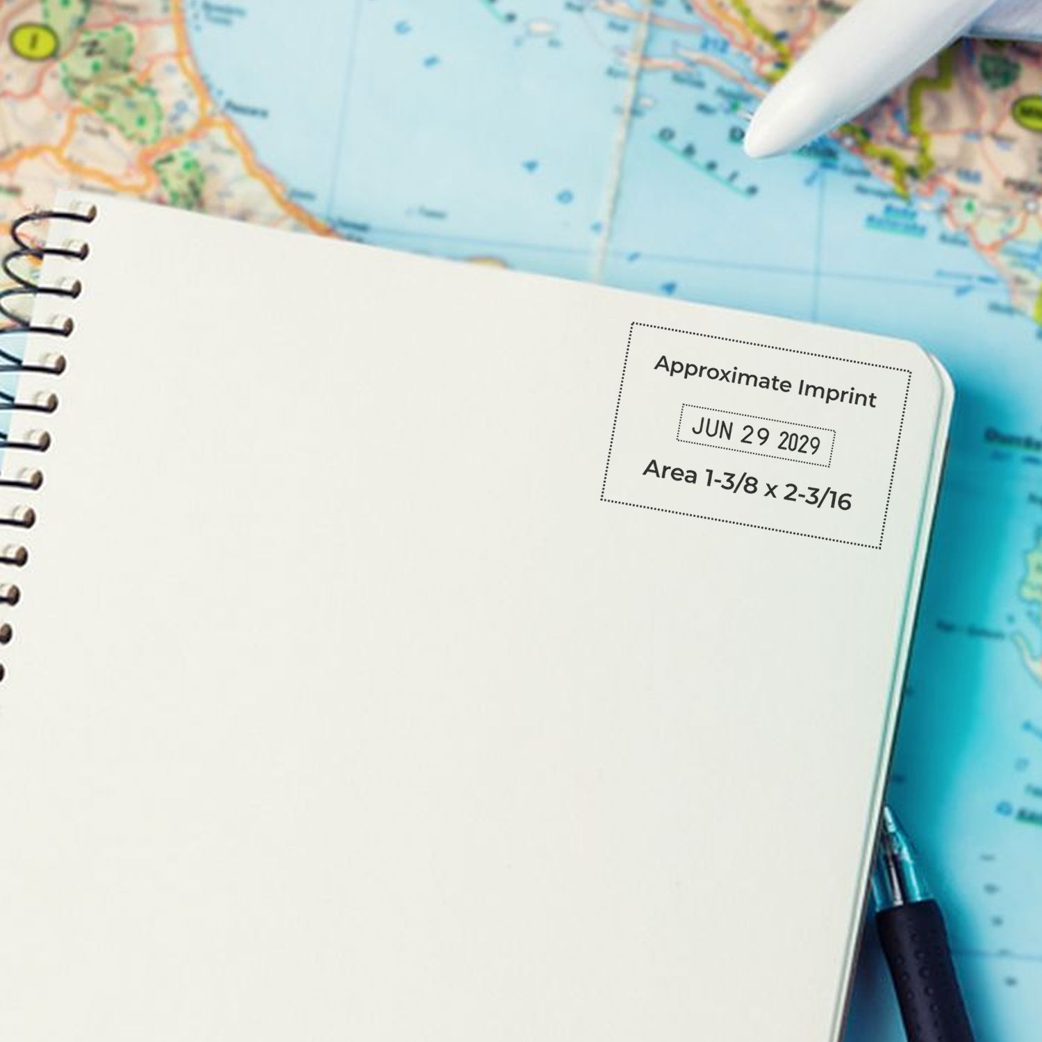 Blank spiral notebook on a world map with pen, ideal for travel planning and itinerary notes.