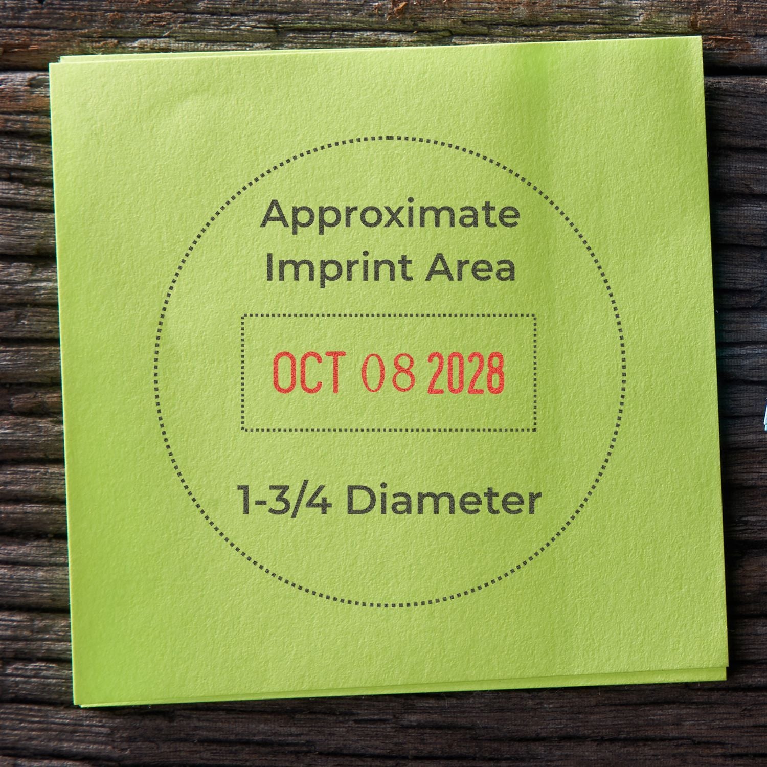 Green sticky note showing approximate imprint area with OCT 08 2028 and 1-3/4 diameter on rustic wood background