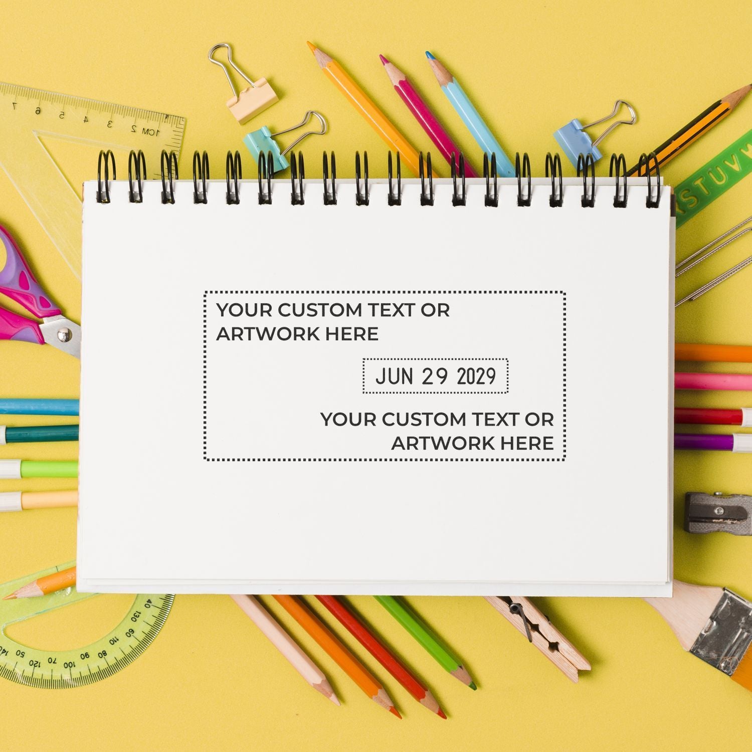 Colorful back-to-school flat lay with blank spiral notebook, pencils, rulers, and stationery on a yellow background for custom text or artwork.
