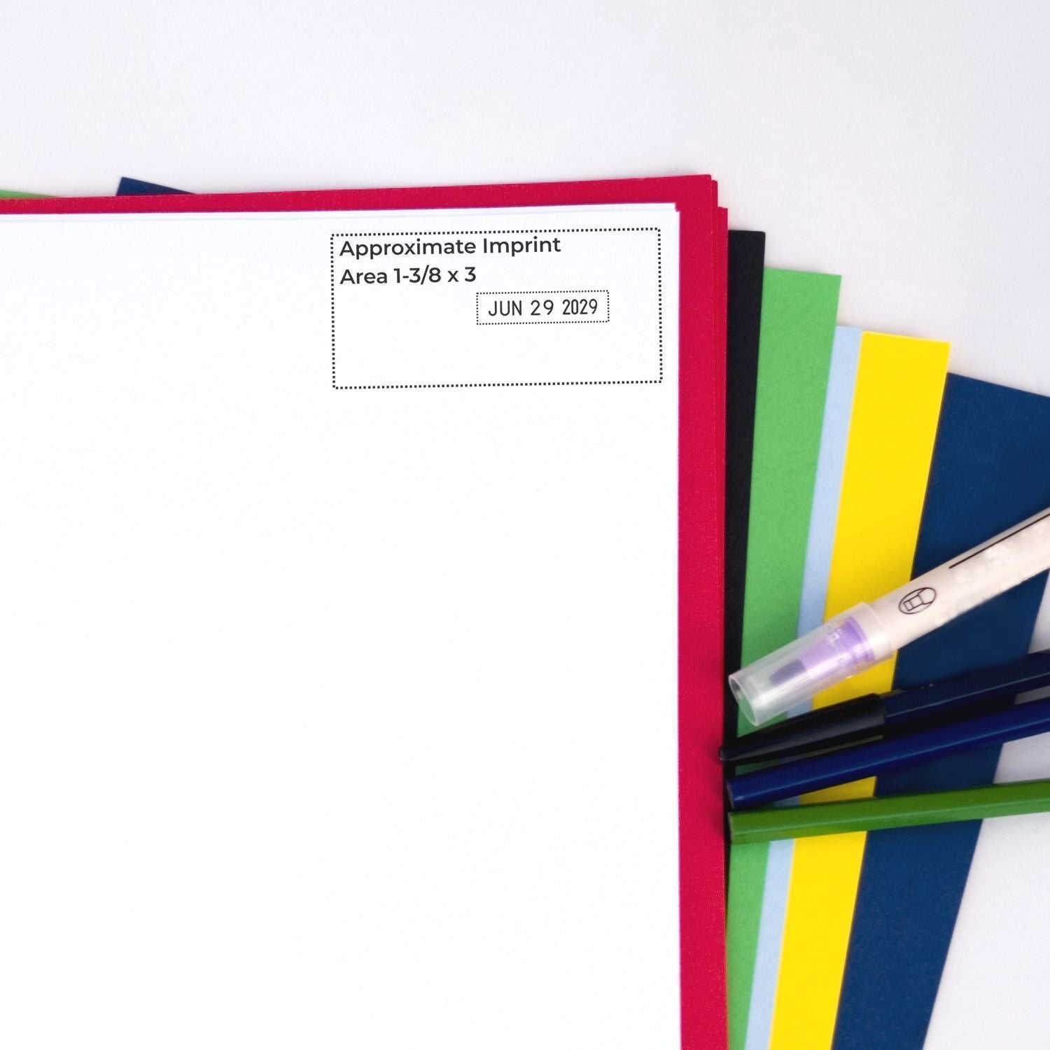 Blank invitation card mockup with approximate imprint area, colorful paper swatches, and pen for custom stationery design.