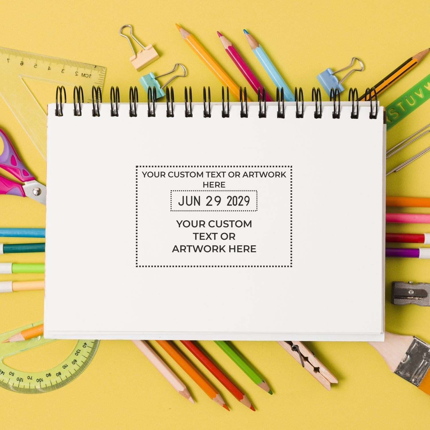 Blank spiral notebook mockup surrounded by colorful school supplies on a yellow background, ideal for school stationery or custom design text.