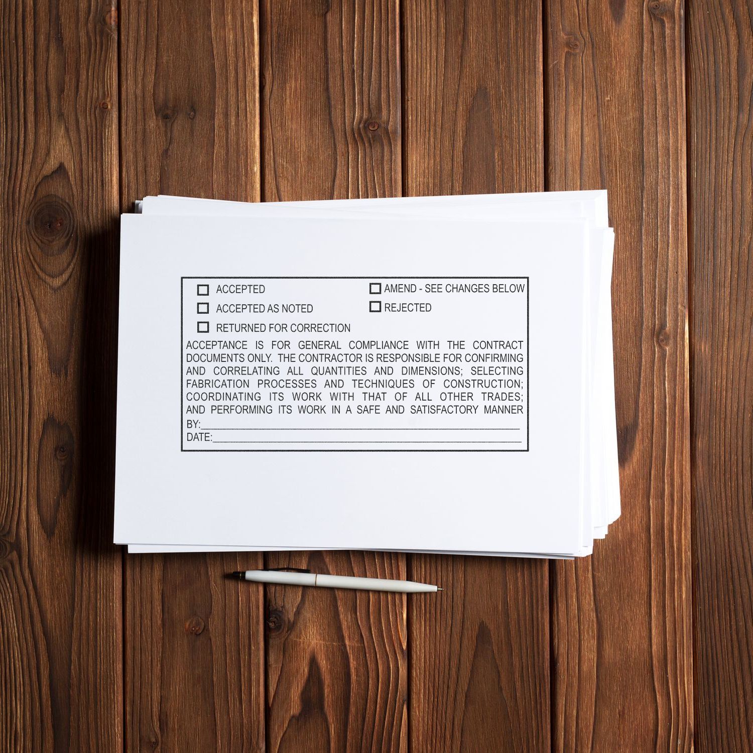 Stack of construction contract approval forms with a pen on a wooden desk