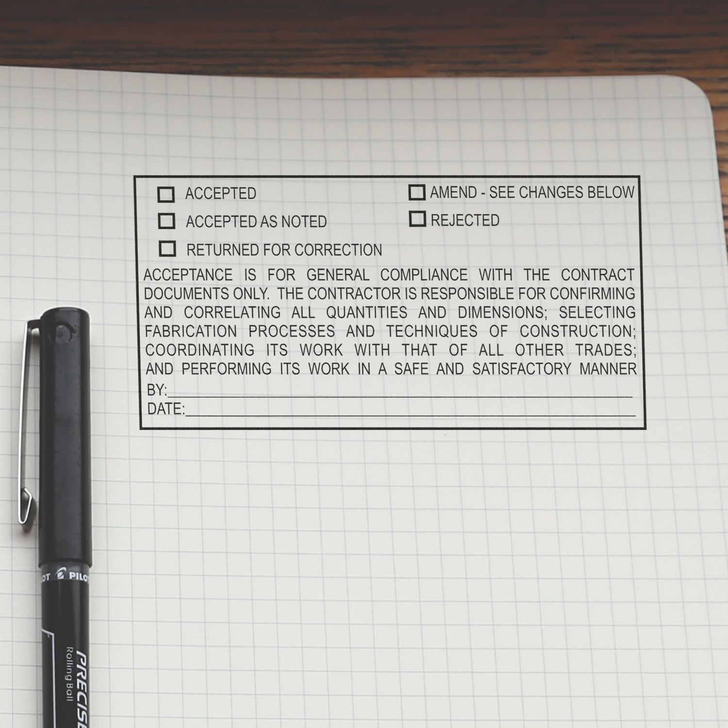Graph paper notebook with a black pen and an architectural submittal approval form showing accepted, rejected, and returned for correction checkboxes.