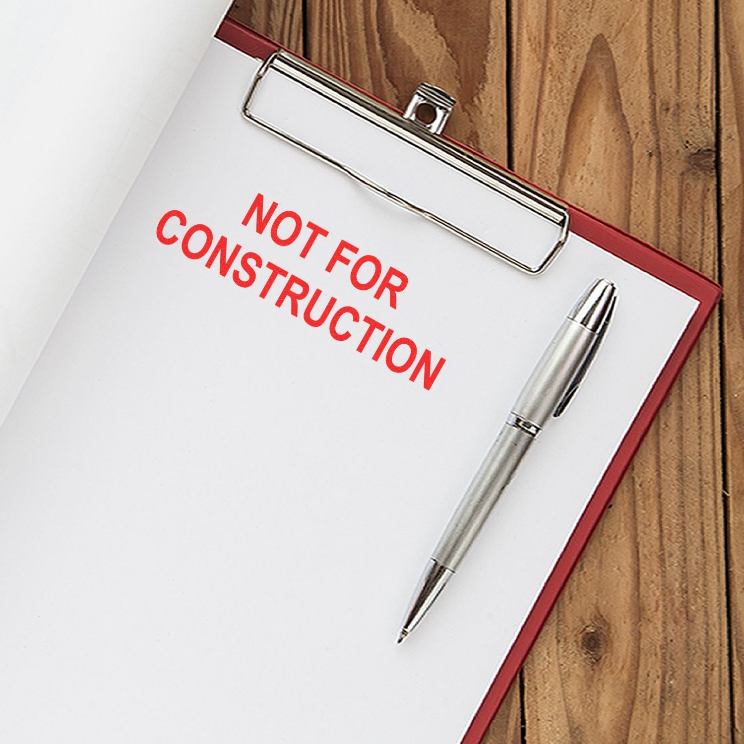 Clipboard with Not for Construction text and pen on wooden desk, office concept image