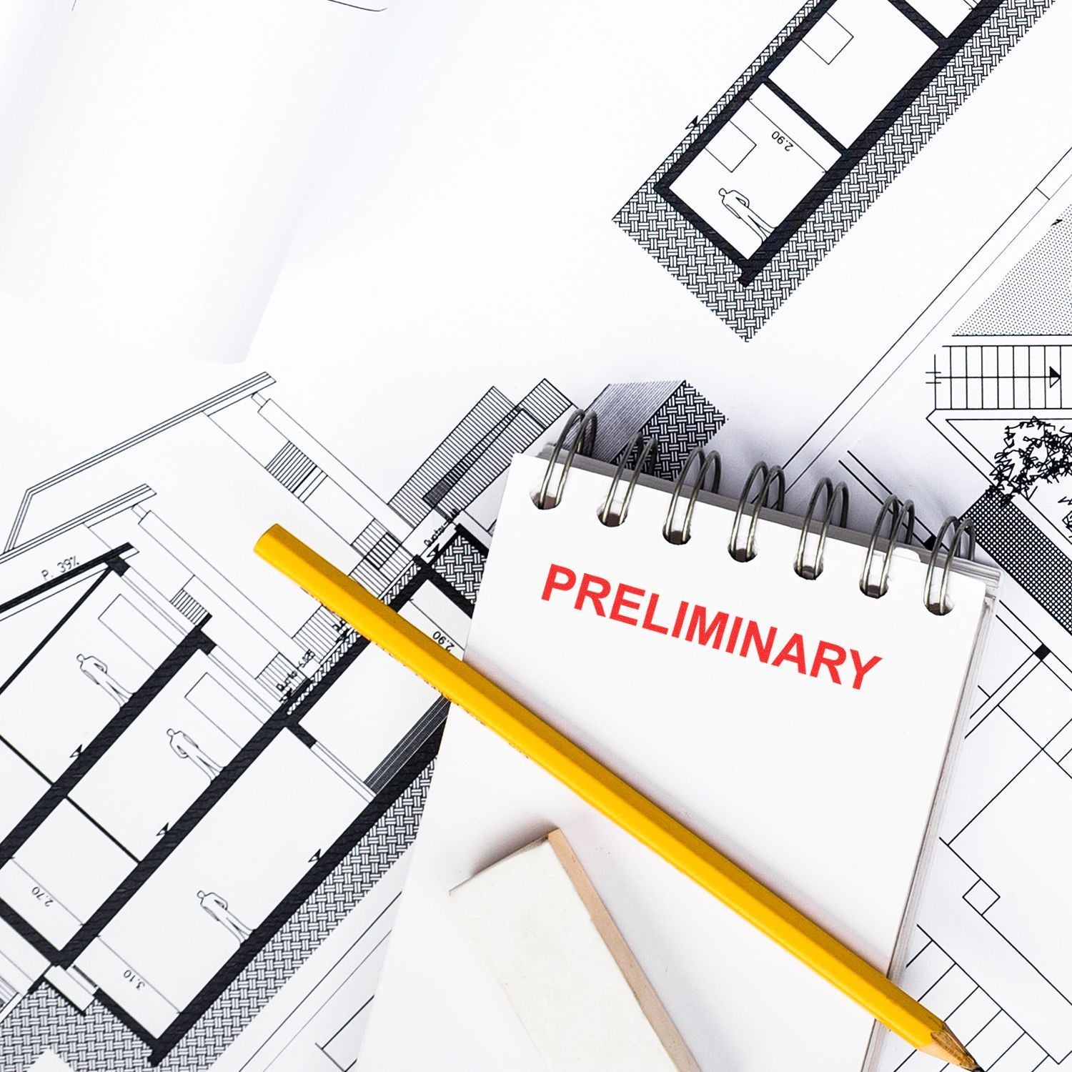 Architectural blueprint floor plans with preliminary notebook and yellow pencil, top view of building design concept.