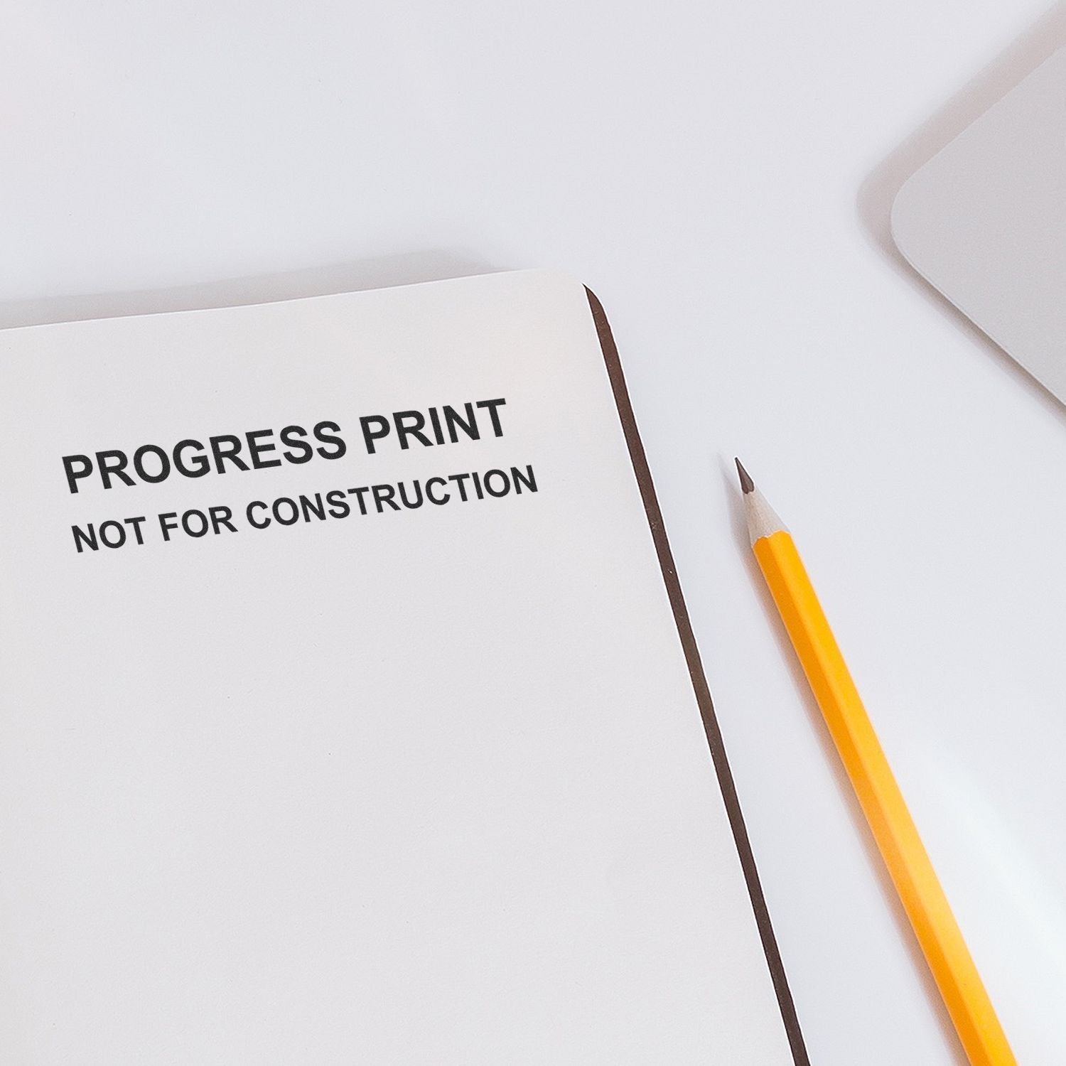 Progress print not for construction document with yellow pencil on white desk, minimalist architectural draft preview.
