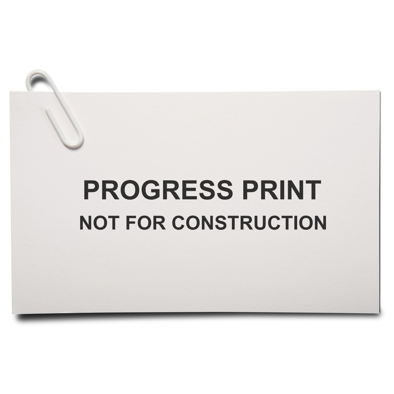 Progress print not for construction note clipped to white paper sheet, architectural drawing status label.