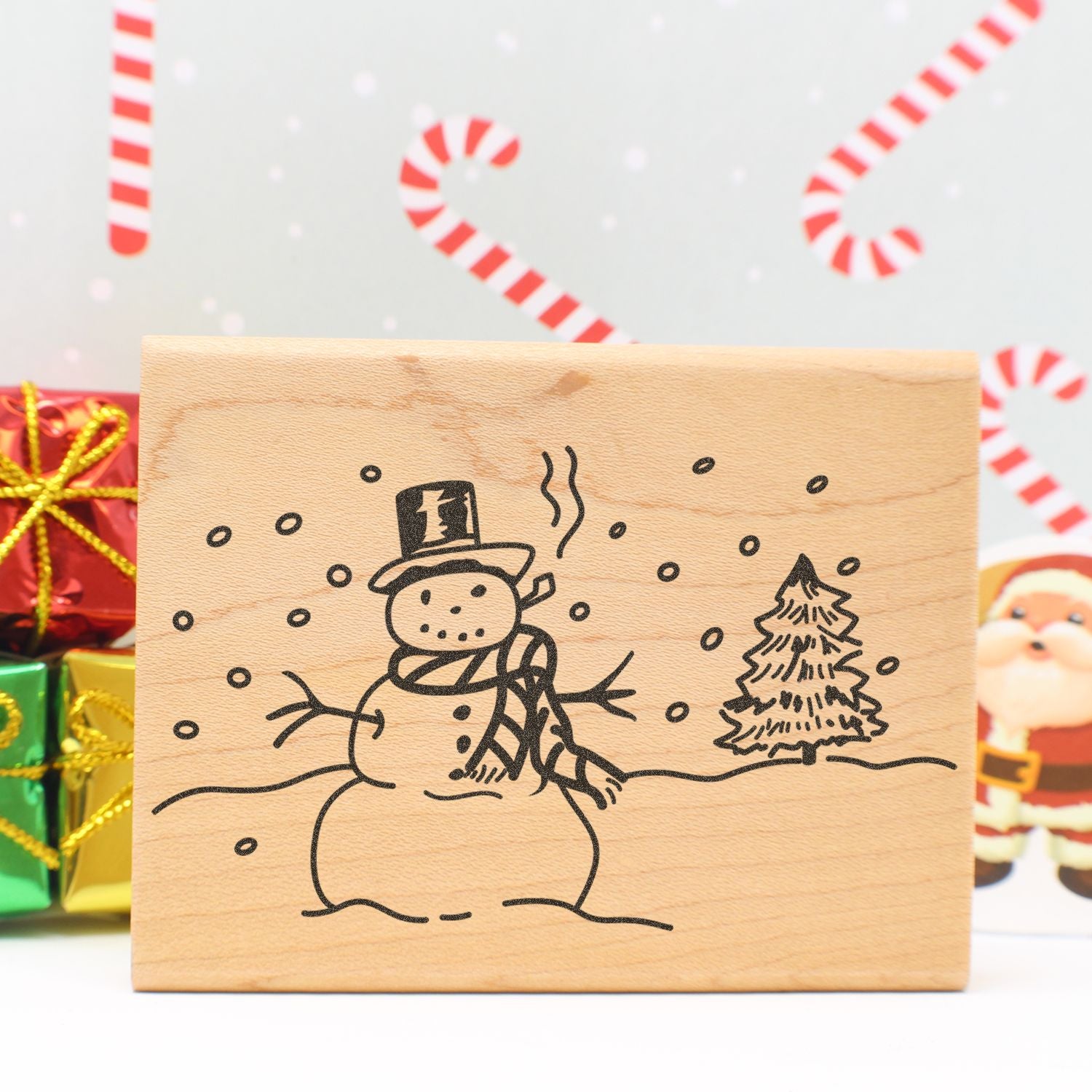Wooden Christmas decoration with a snowman and tree design, festive holiday gifts, and candy cane background.